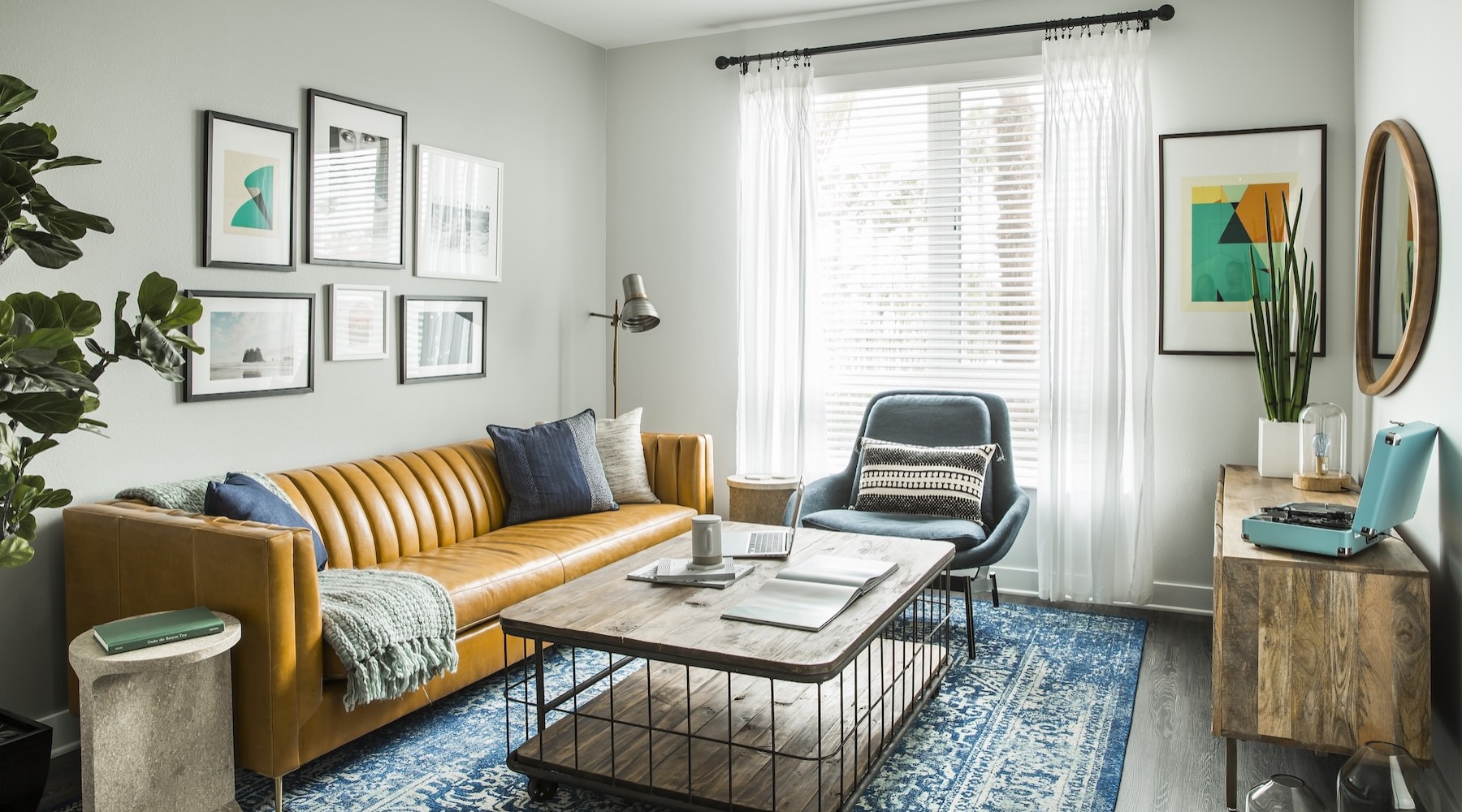 a living room with a couch, tables and a chair