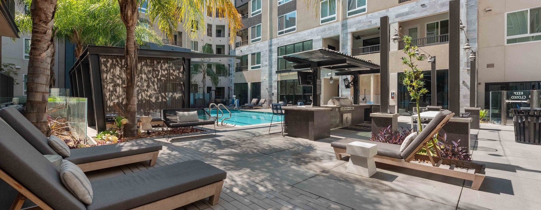chairs and cabanas in a courtyard near a pool