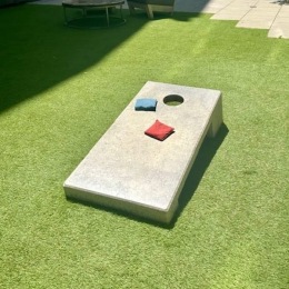 a grassy area with cornhole